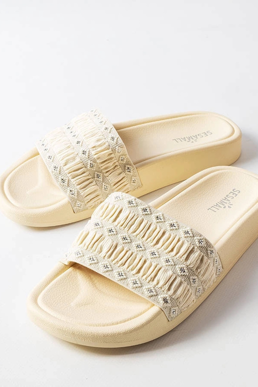 Chanclas beige decoradas con volantes...