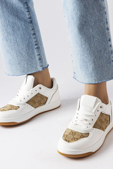 Zapatillas blancas decoradas con el monograma de Isidora