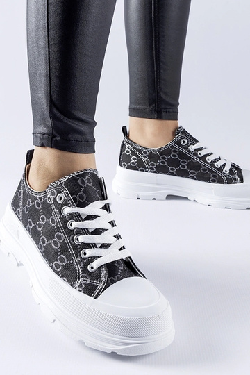 Zapatillas negras decoradas con el monograma de Antonella
