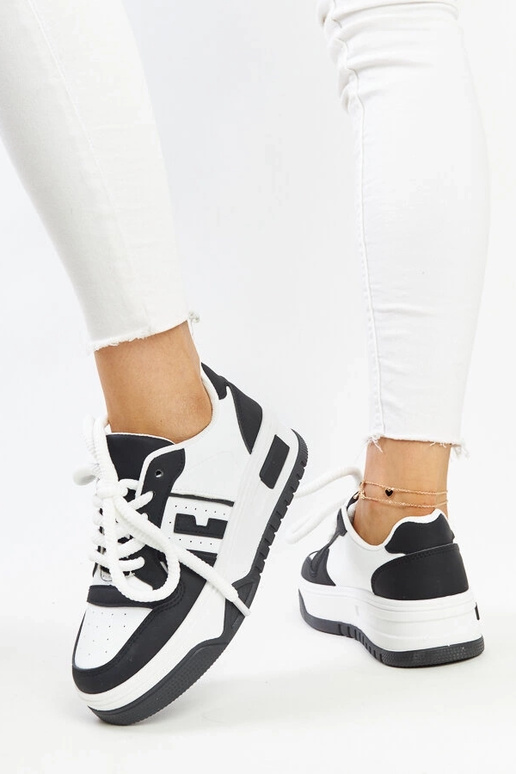 Zapatillas blancas y negras con suela...