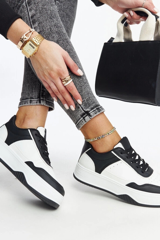 Zapatillas blancas y negras con suela...