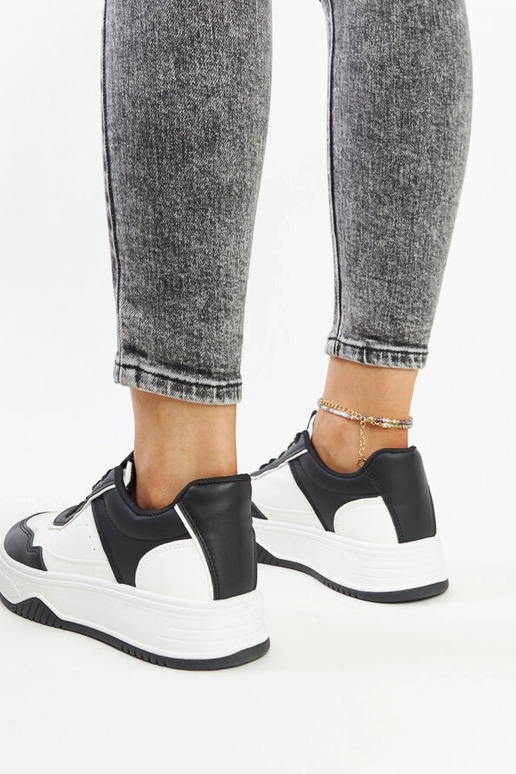 Zapatillas blancas y negras con suela...