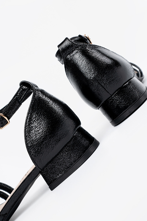 Estilo elegante de color negro sandalias en un tacón bajo