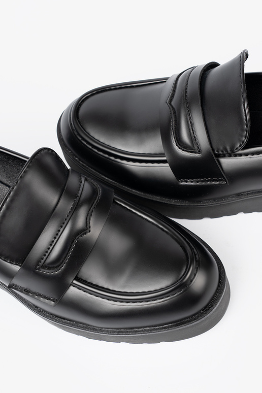 Estilo elegante de color negro mocasines sobre una suela gruesa