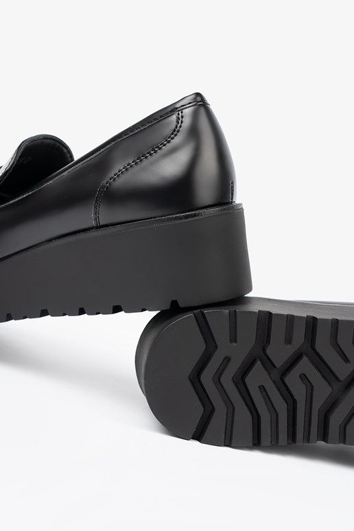 Estilo elegante de color negro mocasines sobre una suela gruesa