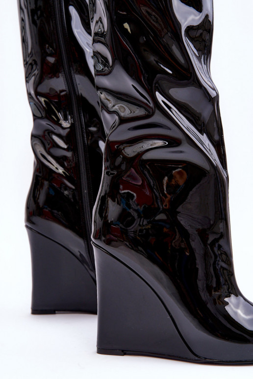 con efecto barniz botas en una cuña de color negro Delinn con efecto barniz botas en una cuña de color negro Delinn