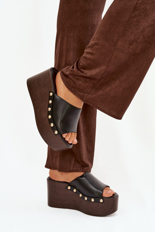 zapatillas de mujer en una cuña con remaches de color negro Tiene quereline