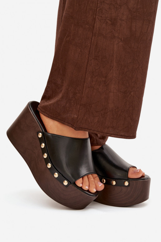 zapatillas de mujer en una cuña con remaches de color negro Tiene quereline