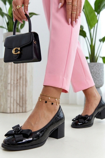 Zapatos de cuero lacados negros sobre una columna Cambell