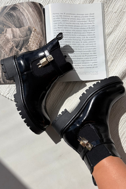 Botines aislados y elegantes con detalles Ze dorados y negros Talyra