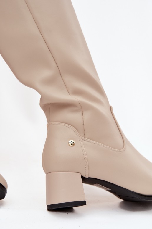 Botas beige aisladas para mujer por encima de la rodilla de cuero con tacones