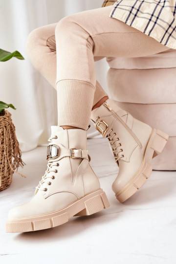 Botas calefactables con hebillas doradas en color beige.