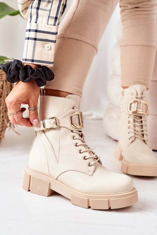Botas calefactables con hebillas doradas en color beige.