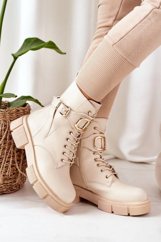 Botas calefactables con hebillas doradas en color beige.