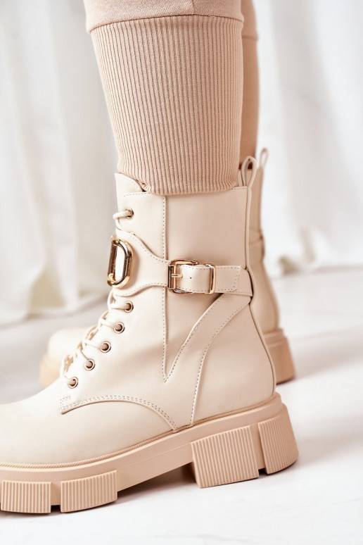 Botas calefactables con hebillas doradas en color beige.