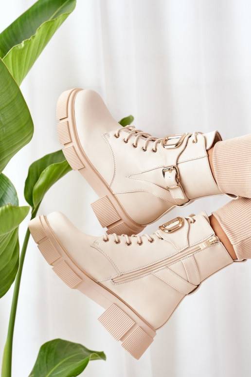 Botas calefactables con hebillas doradas en color beige.