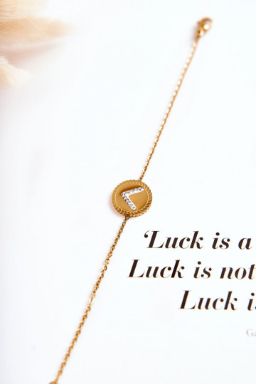 Pulsera de mujer con adornos y ojos de circonitas en color dorado.