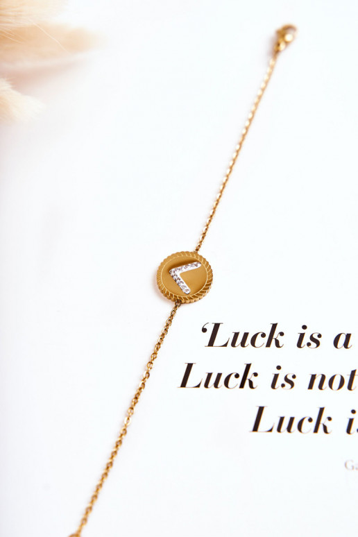 Pulsera de mujer con adornos y ojos de circonitas en color dorado.